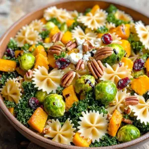 - 12 oz pasta (preferably farfalle or penne) - 1 cup butternut squash, diced into small cubes - 1 cup Brussels sprouts, trimmed and halved - 1 cup kale, stems removed and chopped - 1/2 cup dried cranberries for a burst of sweetness - 1/2 cup pecans, roughly chopped for crunch - 1/4 cup feta cheese, crumbled for creaminess The main ingredients in this pasta salad bring rich flavors and textures. The pasta forms the base, giving a great bite. Seasonal vegetables like butternut squash and Brussels sprouts add sweetness and a slight crunch. The kale offers a fresh note, while dried cranberries provide a pop of color and sweetness. Pecans add a lovely crunch, and feta gives a creamy finish. - 1/3 cup extra-virgin olive oil - 2 tablespoons apple cider vinegar - 1 tablespoon pure maple syrup for sweetness - 1 teaspoon Dijon mustard for a tangy kick - Salt and freshly ground black pepper to taste The dressing is simple yet full of flavor. Extra-virgin olive oil provides healthy fat, making the salad rich. Apple cider vinegar adds a tangy note, balancing the sweetness from the maple syrup. Dijon mustard enhances the flavor with its sharpness. Don't forget to season with salt and pepper to bring everything together. This dressing perfectly complements the vibrant ingredients. Preheating the Oven Start by preheating your oven to 400°F (200°C). This heat helps to caramelize the vegetables, making them sweet and tasty. Roasting Process On a large baking sheet, spread out 1 cup of diced butternut squash and 1 cup of halved Brussels sprouts. Drizzle them with 1/3 cup of extra-virgin olive oil. Season with salt and freshly ground black pepper. Toss them well to coat. Roast the vegetables for 25-30 minutes. They are ready when they are fork-tender and nicely caramelized. Boiling Instructions While the vegetables roast, bring a pot of salted water to a boil. Add 12 oz of pasta, preferably farfalle or penne. Cook the pasta according to the package instructions until al dente. Cooling the Pasta Once done, drain the pasta and rinse it under cold water. This step cools the pasta down and keeps it from becoming mushy. Mixing Vegetables and Pasta In a large mixing bowl, combine the cooled pasta, roasted butternut squash, Brussels sprouts, 1 cup of chopped kale, 1/2 cup of dried cranberries, and 1/2 cup of roughly chopped pecans. Stir gently to mix everything well. Preparing the Dressing For the dressing, whisk together 1/3 cup of olive oil, 2 tablespoons of apple cider vinegar, 1 tablespoon of pure maple syrup, and 1 teaspoon of Dijon mustard in a small bowl. Add a pinch of salt and pepper, and blend until smooth. Pour the dressing over the pasta salad and toss carefully to coat all ingredients. Achieving Optimal Flavor Roasting brings out the sweet and rich flavors in vegetables. Start with fresh, in-season produce like butternut squash and Brussels sprouts. Cut them into small, even pieces. This helps them cook evenly. Drizzle with olive oil and season well with salt and pepper. Roast until they are golden and tender. This usually takes about 25-30 minutes at 400°F. Timing for Vegetables Roast your vegetables first. This allows them to cool slightly before mixing. You want the vegetables to be warm, not hot, when you add them to the pasta. If you roast them too early, they may cool down too much. Balancing Sweetness and Acidity Your dressing should have a nice balance of sweet and tangy flavors. Use apple cider vinegar and maple syrup in the right amounts. This mix gives the salad a fresh taste. If you like it sweeter, add more maple syrup. If you prefer it tangy, add more vinegar. Customizing Flavor Profiles Feel free to adjust the dressing to suit your taste. You can add garlic for a punch or herbs like thyme or rosemary for extra flavor. Just remember to mix well to combine all the flavors. Serving Suggestions Serve your pasta salad in a large, decorative bowl. This makes it look inviting. For a special touch, you can use a platter. Garnishing Tips Add extra crumbled feta cheese on top for creaminess. A sprinkle of chopped pecans adds crunch. For a finishing touch, drizzle a little balsamic glaze over the salad. This adds a nice shine and flavor, making it even more appealing. {{image_4}} You can change the vegetables in this salad to suit your taste. Try using sweet potatoes instead of butternut squash. They add a nice sweetness. You can also swap Brussels sprouts for roasted carrots. Their natural sweetness works well. For a crunch, add bell peppers or snap peas. They bring freshness and color. Cheese adds creaminess to the salad. If you prefer a different taste, use goat cheese instead of feta. Goat cheese has a tangy flavor that fits well with the other ingredients. You can also skip the cheese for a lighter dish. Nutritional yeast can give you a cheesy flavor without dairy. To make this salad vegan, simply remove the cheese. Use a vegan dressing made with tahini or avocado. These options add creaminess without dairy. You can also add chickpeas for extra protein. They make the salad filling and nutritious. If you need a gluten-free version, choose gluten-free pasta. There are many types available today. Quinoa or lentil pasta are great choices. They provide a different texture and flavor, making the salad unique. Just make sure to check the label for gluten-free ingredients. Storing leftovers from your Fall Harvest Pasta Salad is easy. Start by letting it cool to room temperature. Transfer the salad to an airtight container. Make sure to remove as much air as possible to keep it fresh. The salad can last in the fridge for up to three days. - Container Recommendations: Choose glass or BPA-free plastic containers. Glass is sturdy and doesn’t stain. Plastic is lighter and easier to store. If you have a large batch, divide it into smaller containers for quick snacks. You can freeze pasta salad, but it may change texture. To freeze, make sure the salad is fully cooled. Place it in a freezer-safe container. Leave some space for expansion. Seal it tightly and label it with the date. The salad can last in the freezer for up to two months. - How to Freeze Pasta Salad: Portion out the salad into smaller servings. This makes it easier to thaw only what you need. Avoid freezing any added cheese or dressing. They do not freeze well and may become watery. - Thawing and Reheating Tips: To thaw, place the container in the fridge overnight. If you're in a rush, you can use the defrost setting on your microwave. After thawing, give it a good stir. Taste it and adjust the seasoning if needed. Yes, you can make this salad a day ahead. I suggest you wait to add the dressing until just before serving. This keeps the pasta and veggies fresh. You can store it in the fridge for up to three days. Just be sure to keep the feta separate if you want it to stay creamy. For a fall harvest salad, think about using: - Butternut squash - Brussels sprouts - Kale - Sweet potatoes - Carrots These veggies add color and flavor. They also provide nutrients that support your health during the colder months. To lighten up the dressing, try these tips: - Use less olive oil and more vinegar. - Swap maple syrup for a splash of lemon juice. - Mix in Greek yogurt for creaminess without extra calories. These changes keep the dressing tasty while cutting down on calories. This post detailed how to create a delicious pasta salad. We explored key ingredients like seasonal vegetables, nuts, and cheese. I provided step-by-step instructions for preparing vegetables, cooking pasta, and mixing everything together. You learned tips on roasting and dressing adjustments. I shared variations for dietary needs and storage guidelines for leftovers. In closing, these insights help make pasta salad easy and fun. Enjoy experimenting with flavors and using fresh ingredients. Your next meal will benefit from this knowledge.