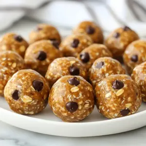 - 1 cup natural peanut butter - 1/2 cup rolled oats - 1/4 cup honey or maple syrup - 1/4 cup chocolate protein powder - 1/4 cup ground flaxseed - 1/2 teaspoon vanilla extract - 1/4 cup mini chocolate chips (optional) - A pinch of sea salt To make peanut butter protein balls, gather these ingredients. Natural peanut butter is key. It gives flavor and creaminess. Rolled oats add texture and help bind the mix. Honey or maple syrup sweetens the balls. You can choose either based on your taste. Next, chocolate protein powder boosts protein content. Ground flaxseed adds fiber and omega-3s. A touch of vanilla extract brings warmth and flavor depth. If you want a treat, mini chocolate chips are a fun option. Finally, sea salt enhances all the flavors. - Calories per serving: About 100 - Protein content: 5 grams - Fiber content: 2 grams These protein balls are not just tasty; they are also healthy. Each ball has about 100 calories, making them a great snack. With 5 grams of protein, they help keep you full. The 2 grams of fiber support your digestion and overall health. These bites fit well into any balanced diet. Enjoy them as a quick snack or a post-workout treat! {{ingredient_image_2}} - Mixing the peanut butter and sweetener Start by taking a large bowl. Add 1 cup of natural peanut butter, 1/4 cup of honey or maple syrup, and 1/2 teaspoon of vanilla extract. Use a spatula or spoon to mix these ingredients. Stir until the mixture is smooth and well combined. Make sure there are no lumps left. - Incorporating dry ingredients Gradually add the rolled oats, chocolate protein powder, ground flaxseed, and a pinch of sea salt. These dry ingredients add texture and nutrition. Mix everything together vigorously. You want a dough-like texture that holds together well. - Shaping the protein balls Now, use your hands to shape the mixture into small balls. Aim for about 1 inch in diameter. If the mixture sticks to your hands, wet them lightly with water. This helps in shaping without the mess. Place the formed balls on a baking sheet lined with parchment paper. Make sure to space them out so they don&rsquo;t stick together. - Recommended chilling time Once all the balls are shaped, put the baking sheet in the refrigerator. Let them chill for at least 30 minutes. This helps the protein balls firm up nicely and makes them easier to eat. - Proper storage methods After chilling, transfer the peanut butter protein balls to an airtight container. Store them in the refrigerator for up to one week. For longer storage, you can freeze them. This way, you have a healthy snack ready whenever you need it. - Ensuring proper consistency: Mix your peanut butter and sweetener well. The mix should be smooth and thick. If it feels too dry, add a bit more sweetener. If it's too wet, add more oats. - Preventing sticking when shaping: Wet your hands lightly with water before shaping the balls. This stops the mixture from sticking to your hands. You&rsquo;ll find it much easier to form them into neat, even balls. - Adding different seeds or nuts: You can change up the texture by adding sunflower seeds or chopped almonds. These add crunch and extra nutrients to your snack. - Substituting sweeteners: If you want less sugar, try using agave nectar or a sugar substitute. You can also skip sweeteners altogether if you prefer a less sweet taste. Pro Tips Use Natural Peanut Butter: Choose a natural peanut butter without added sugars or oils for a healthier option and better flavor. Customize Sweetness: Adjust the amount of honey or maple syrup according to your taste preference; you can even use a sugar substitute if desired. Experiment with Mix-Ins: Feel free to add different mix-ins like chopped nuts, dried fruit, or seeds to customize your power balls even further. Perfect Storage: Keep the power balls in an airtight container in the fridge for freshness, or freeze them for quick snacks later on. {{image_4}} You can change the taste of your peanut butter protein balls easily. One fun option is to add cocoa powder for a chocolate flavor. Simply mix in a few tablespoons of cocoa powder during the dry ingredient stage. You can also use vanilla extract instead of cocoa for a sweet vanilla taste. If you want a warm touch, try adding a sprinkle of cinnamon. It gives a nice twist and pairs well with peanut butter. If you follow a vegan diet, you can swap honey for maple syrup. This keeps your snack plant-based and still sweet. For those who need gluten-free options, use certified gluten-free rolled oats. This way, everyone can enjoy these tasty treats without worries. Peanut butter protein balls taste great with different fruits. Here are some ideas: - Bananas: They add sweetness and creaminess. - Apples: Crunchy apples pair well with the soft texture of the balls. - Berries: Blueberries or strawberries add a fresh burst of flavor. For drinks, consider these combos: - Milk: A glass of cold milk complements the protein balls perfectly. - Smoothies: Blend a fruit smoothie for a balanced snack. - Herbal tea: A warm cup can be soothing and tasty. You can serve peanut butter protein balls in fun ways. Try these: - Presentation in jars: Place the balls in small jars for parties. Top with extra chocolate chips or chia seeds for a nice look. - Meal prep: Pack them in small containers for easy snacks on the go. They are perfect for busy days or workouts. These ideas make your snack not just tasty but also fun to eat. Peanut butter protein balls last about one week in the fridge. Store them in an airtight container. This keeps them fresh and tasty. If you see any signs of spoilage, throw them out. Always trust your senses! Yes, you can freeze peanut butter protein balls. They freeze well and can last up to three months. Just place them in a freezer-safe container. When ready to eat, thaw them in the fridge. This way, you always have a healthy snack on hand! You can use almond butter or sunflower seed butter. Both options give a similar taste and texture. If you have nut allergies, sunflower seed butter is a great choice. It&rsquo;s safe and still packed with nutrients! Yes, these protein balls are great for kids! They are healthy and easy to make. Plus, kids love the sweet taste and chocolate chips. They make a fun after-school snack or a treat during playtime. Just keep an eye on portion sizes! This blog post shared a simple recipe for peanut butter protein balls. We covered all the ingredients and provided step-by-step instructions. You learned how to customize flavors and make dietary adjustments. We also included tips for serving and storing. Healthy snacks should be easy and fun to make. With these tips, you can enjoy tasty bites anytime! So get your ingredients ready and try making these protein balls today. They will keep you fueled and satisfied.